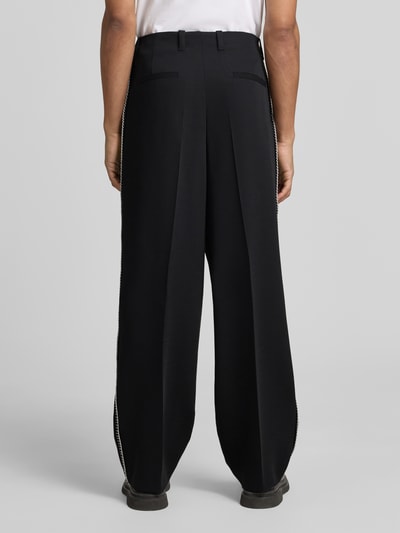 Männermodel trägt Wide Fit HOSE mit Bundfalten und Schurwoll-Anteil Modell 'FEDIX' von HUGO, Two-Tone-Optik, Twill, Ganzkörperansicht Rückansicht.