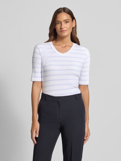 Kobiece model prezentuje T-shirt mit Streifenmuster und V-Ausschnitt von Christian Berg Woman, mieszanka bawełny i elastanu, krój regular fit, wzór w paski, dekolt w serek, długość tyłu w rozmiarze S: 55 cm, widok całej sylwetki z przodu.