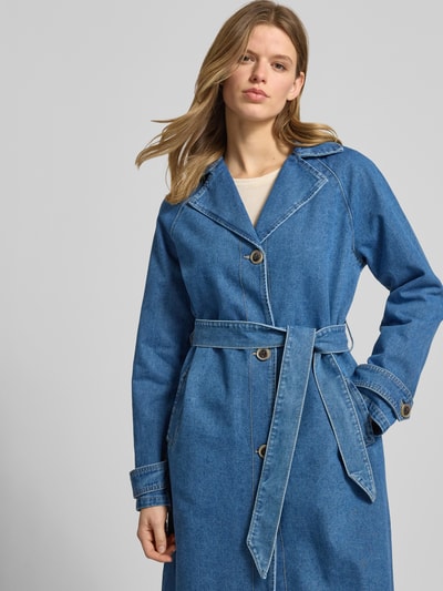 Vrouwenmodel draagt Loose Fit Trenchcoat uit denim model 'MALOU' van Only met contrastnaden, reverskraag, tailleriem, katoenmix, nahaufnahme bovenstuk.