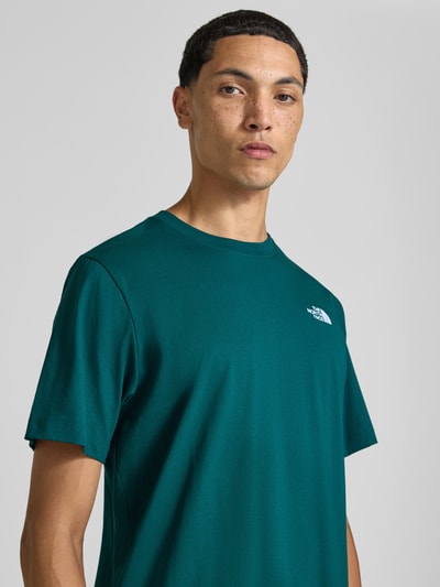 Mannermodel draagt Regular fit t-shirt met ronde hals Model 'EVOLUTION' van The North Face in groen met labelstitching, ruglengte maat M 72 cm, Nahaufnahme Oberkörper.