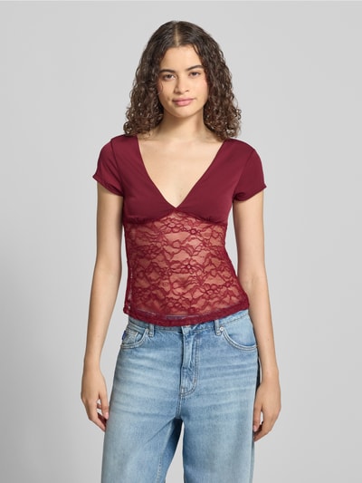 Frauenmodel trägt T-Shirt mit V-Ausschnitt und Spitze von Gina Tricot in Slim-Fit, Material-Mix mit Stretch-Anteil, Rückenlänge 51 cm, Ganzkörperansicht von vorne.