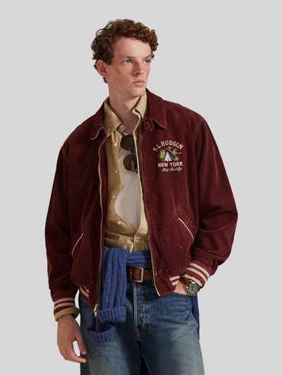 Mężczyznamodel nosi Regular Fit Blouson aus Baumwoll-Cord von Polo Ralph Lauren z bordowego sztruksu z logo, gładki wzór, całkowity widok z przodu.