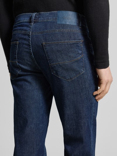 Männermodel trägt Sraight Fit Jeans mit Eingrifftaschen Modell 'Cadiz' von Brax aus Baumwoll-Elasthan-Mix im Used-Look, Detailaufnahme Rückansicht.