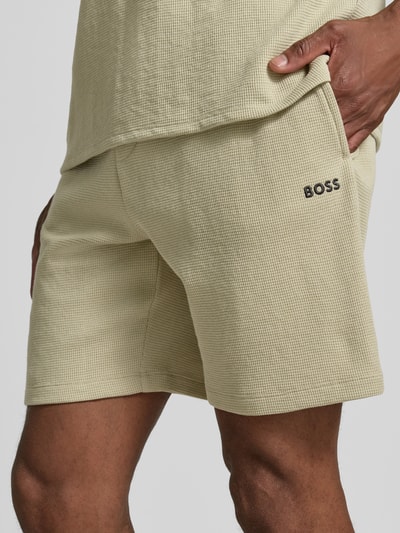 Männermodel trägt Regular Fit Sweatshorts aus Baumwoll-Mix von BOSS in hellem Beige mit Waffelstruktur, Nahaufnahme Oberschenkel, Herren Sweatshorts von BOSS
