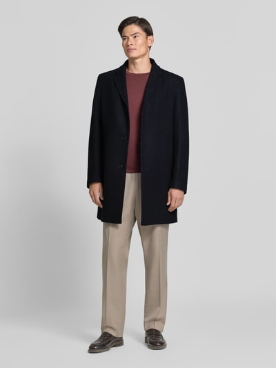 Männermodel trägt Regular Fit Mantel aus Woll-Mix von HECHTER PARIS in Dunkelblau mit Reverskragen, Ganzkörperansicht von vorne. Rückenlänge 95 cm, Schulterbreite 43 cm, Brustweite 57 cm, Ärmellänge 67 cm.