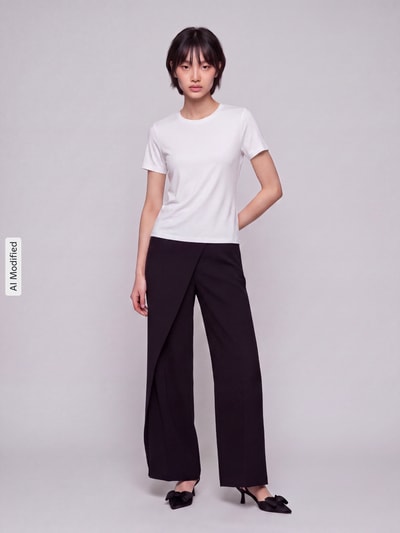 Frauenmodel trägt Slim Fit T-Shirt aus Baumwoll-Mix Modell 'RILEY' von ONLY in Weiß, kombiniert mit schwarzer Hose, Ganzkörperansicht von vorne, KI-modifiziertes Bild. Damen T-Shirt von ONLY.
