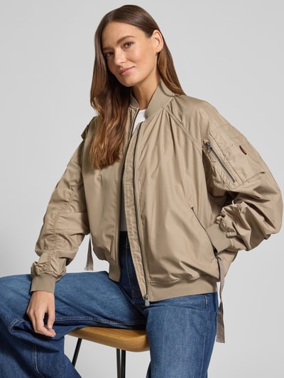 Vrouwenmodel draagt Bomberjack met ritssluitingzakken model 'LIL' van SAVE THE DUCK in beige materiaalmix met stretch, regular fit, opstaande kraag, schouderbreedte 42 cm, borstwijdte 61 cm, mouwlengte 70 cm, ruglengte 53 cm, voorkant bovenlichaam close-up.