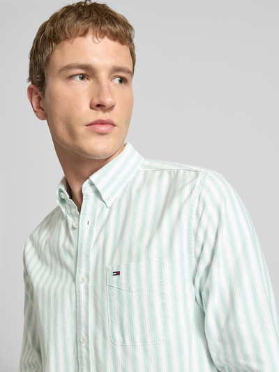 Männermodel trägt Regular Fit Freizeithemd aus reiner Baumwolle von Tommy Jeans, gestreift, Optik:Allover-Muster, Nahaufnahme Oberkörper.