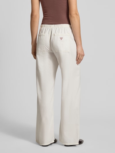 Frauenmodel trägt Wide Leg Jeans mit Tunnelzug von Guess Jeans aus Baumwoll-Lyocell-Mix, helle Farbe, glatte Textur, Ganzkörperansicht Rückansicht. Bundweite bei Größe 27/32: 40 cm, Innenbeinlänge: 79 cm, Damen Jeans mit Knopf- und Reißverschluss.