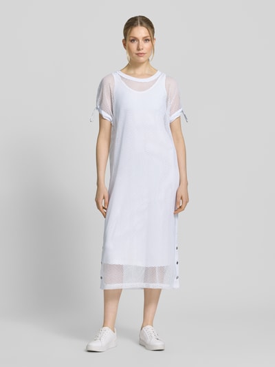 Frauenmodel trägt Semitransparentes Midikleid mit Rundhalsausschnitt von Marc Cain in Weiß, gerader Schnitt, Material-Mix, Ganzkörperansicht von vorne.