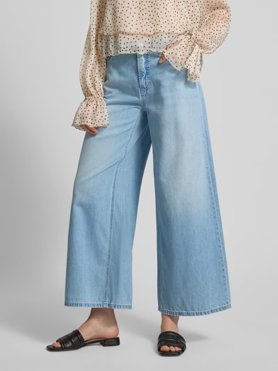 Kobieta prezentuje Regular Fit Loose Fit Jeans aus reiner Baumwolle Modell 'PALAZZO' von Cambio w jasnoniebieskim odcieniu, materiał denim, krój regular fit, długość cropped, 5 kieszeni, szlufki na pasek, naszywka z logo, zapięcie na guzik i kryty zamek, twill z czystej bawełny; całkowite ujęcie sylwetki z przodu.