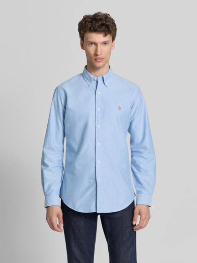 Männermodel trägt Regular Fit vrijetijdsoverhemd uit puur katoen van Polo Ralph Lauren, lichtblauw, gestikt logo, oxford, gestreept motief, button-downkraag, doorlopende knoopsluiting, extra lange mouwen, manchet, achterpas met cacharelplooi. Ganzkörperansicht van voren.