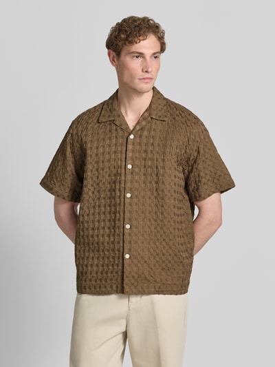 Męski model nosi Relaxed Fit Freizeithemd aus reiner Baumwolle Modell 'MONTY' od SELECTED HOMME, efekt: jednolity kolor, krój relaxed fit, kołnierzyk koszulowy, listwa guzikowa na całej długości, pas na plecach, krótki rękaw, wykończenie materiału: żakard, materiał: bawełna, brązowa faktura, gładkie guziki, tekstura 3d, Ganzkörperansicht z przodu.