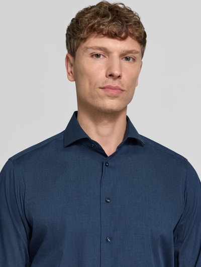 Männermodel trägt Regular Fit Business-Hemd mit Haifischkragen von Christian Berg Men aus reiner Baumwolle in Dunkelblau, Nahaufnahme Oberkörper.
