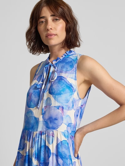 Frauenmodel trägt Midikleid aus Viskose Modell 'Vi44vii' von ZABAIONE mit blau-lila Allover-Muster, Nahaufnahme Oberkörper.