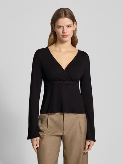 Vrouwenmodel draagt Slim Fit Langarmshirt uit viscosemix model 'SINI' van Only in wikkel-look, V-hals, label stitching, kant; voorkant bovenlichaam close-up.