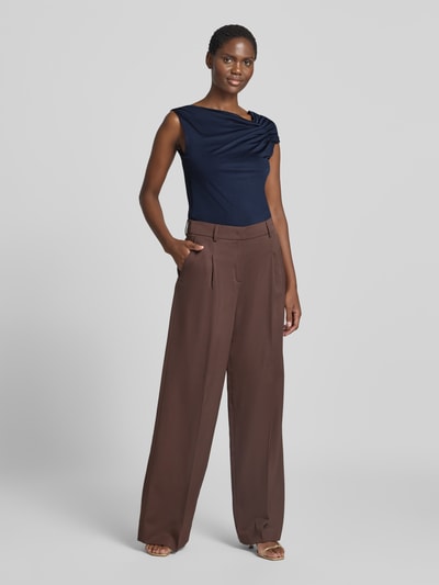 Frauenmodel trägt dunkelblaues Relaxed Fit Top aus Viskose-Mix Modell 'JOIA' von BOSS, kombiniert mit brauner, weiter Hose, Ganzkörperansicht von vorne, Damen Top von BOSS.