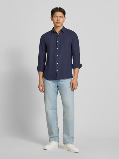 Männermodel trägt Slim Fit Freizeithemd aus Baumwoll-Leinen-Mix Modell 'CAIDENLS SOLID' von Only & Sons, dunkelblau, Ganzkörperansicht von vorne.