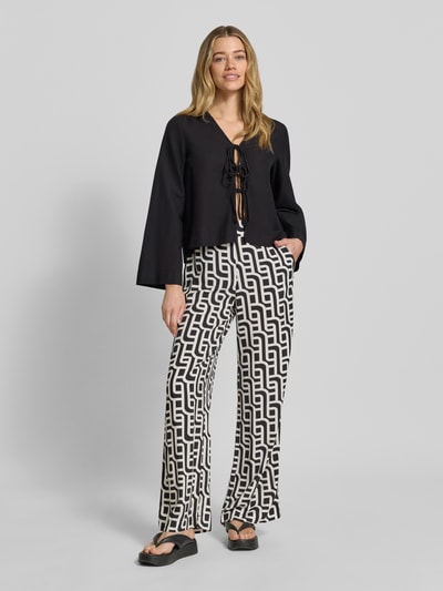 Vrouwenmodel draagt Wide Leg Pants aus Viskose mit Eingrifftaschen van Christian Berg Woman met grafisch zwart-wit patroon, wide fit, elastische band, steekzakken, zuiver viscose, los model, ganzlichaamsaanzicht van voren.