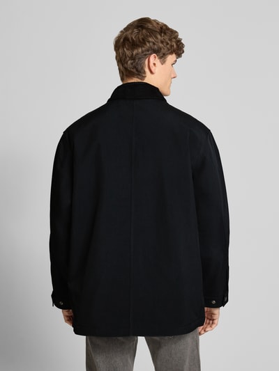 Männermodel trägt Oversized Jacke mit Logo-Patch Modell 'Adair' von Carhartt Work In Progress in Schwarz, Rückenansicht, Herrenjacke mit Cord-Besatz, Umlegekragen und Taschen, Ganzkörperansicht Rückansicht.