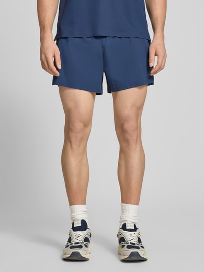 Männermodel trägt Shorts mit elastischem Bund Modell 'ERUDITO' von Ellesse in Blau, Material-Mix mit Stretch-Anteil, Regular-Fit, Ganzkörperansicht von vorne.