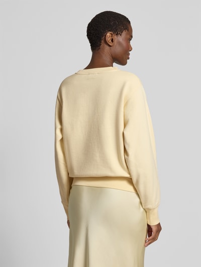 Frauenmodel trägt Regular Fit Sweatshirt mit Logo-Detail von Anine Bing in Creme, reine Baumwolle, elastische Abschlüsse, Ganzkörperansicht Rückansicht.