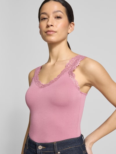 Frauenmodel trägt Slim Fit Tank Top aus Viskose-Mix Modell 'ROSA' von Vero Moda in Rosa mit Spitzenbesatz, Nahaufnahme Oberkörper.