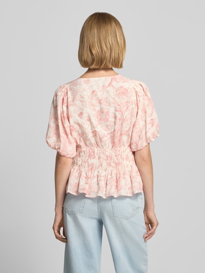 Vrouwenmodel draagt Blusenshirt met Puffärmeln und V-Ausschnitt Model 'Minutti' van Neo Noir, mix van katoen en viscose, getailleerd model, all-over look, v-hals, pofmouwen, ruglengte maat 36: 54 cm, mouwlengte maat 36: 25 cm, geheel in zachte roze en witte tinten met bloemenpatroon, textuur: gladde stof, Ganzkörperansicht Rückansicht.