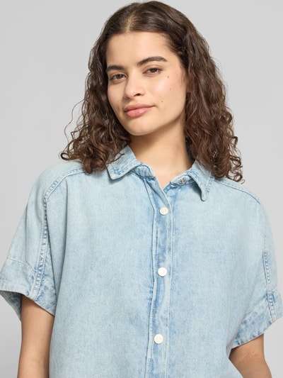 Frauenmodel trägt Relaxed Fit Kurzarmbluse aus reiner Baumwolle von Marc O'Polo Denim mit Denim-Optik, Hemdblusenkragen, Knopfleiste, Nahaufnahme Oberkörper.