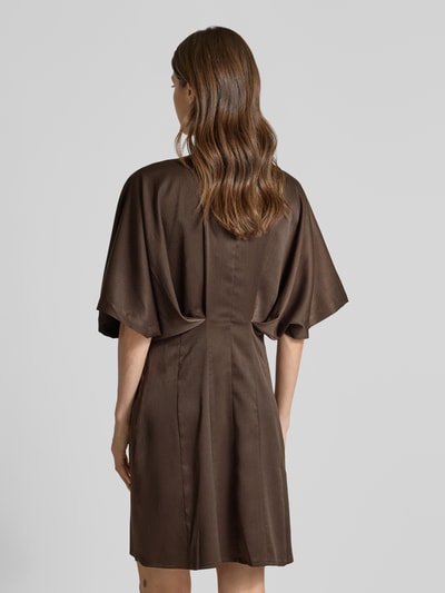 Frauenmodel trägt knielanges Kleid mit Viskose-Anteil Modell 'VIANNA' von Copenhagen Muse in Braun, elastischer Material-Mix, Satin, taillierte Passform, Rückansicht Ganzkörperansicht.