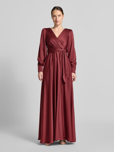 Frauenmodel trägt Tailliertes Abendkleid mit Bindegürtel von Jake*s Cocktail in Bordeaux, glatte Oberfläche, Langarm, Ganzkörperansicht von vorne.