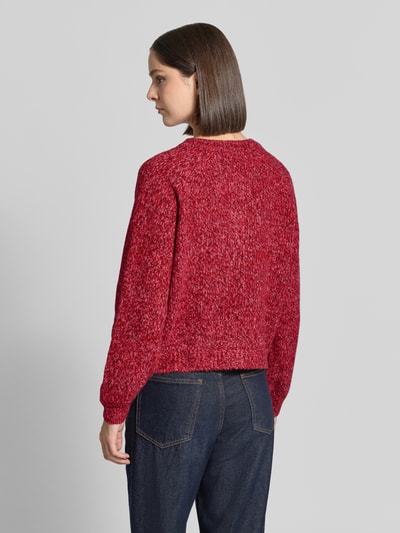 Frauenmodel trägt Relaxed Fit Strickjacke aus Woll-Mix Modell 'Nova' von LOLLYS LAUNDRY in meliertem Rotton, grobe Strickstruktur, kombiniert mit dunkelblauer Jeans, Rückenansicht, Damen Strickjacke, langärmlig, durchgehende Knopfleiste, Rückenlänge 52 cm, Ärmellänge 47 cm.