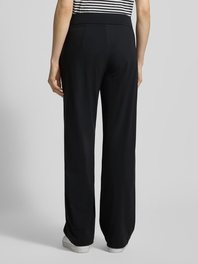 Frauenmodel trägt Straight Leg Jogpants aus Hightech Jersey Modell 'CANDICE' von Raffaello Rossi in Schwarz mit elastischem Bund, Ganzkörperansicht Rückansicht, Damen, Innenbeinlänge 84 cm, Bundweite bei Größe 36: 40 cm, glatte Textur.
