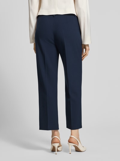 Frauenmodel trägt Wide Fit Stoffhose mit Viskose-Anteil Modell 'Olessa' von Raffaello Rossi in Dunkelblau mit Bügelfalten und Crêpe-Verarbeitung, Haken- und Reißverschluss, Elastischer-Material-Mix, Ganzkörperansicht Rückansicht.