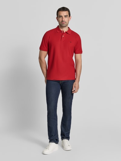 Männermodel trägt Regular Fit Poloshirt mit Label-Stitching von Fynch-Hatton, Reine Baumwolle, Knopfleiste, Rückenlänge 72 cm, Ganzkörperansicht von vorne.