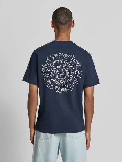 Männermodel trägt Oversized T-Shirt mit Logo-Stitching von Scotch & Soda, dunkelblau, reine Baumwolle, lockerer Schnitt, Rückansicht, Ganzkörperansicht Rückansicht