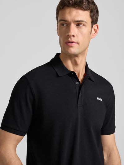 Männermodel trägt Regular Fit Poloshirt aus reiner Baumwolle Modell 'DONOS222' von HUGO, Optik: Unifarben, Nahaufnahme Oberkörper.