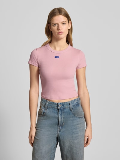 Kobiecy model nosi damski t-shirt Slim Fit T-Shirt aus Baumwoll-Mix Modell 'BABY TEE_B' od Hugo Blue, jednolity kolor, okrągły dekolt, krótki rękaw, prążkowana faktura, mieszanka bawełny, całkowity widok z przodu.