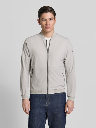 Männermodel trägt Regular Fit Jacke mit Stehkragen Modell 'Campo' von SCANDINAVIAN EDITION in Beige mit Zweiwege-Reißverschluss, Eingrifftaschen, elastische Abschlüsse, Vorderansicht Ganzkörperansicht. Rückenlänge 67 cm, Schulterbreite 44 cm, Brustweite 51 cm, Ärmellänge 64 cm, Größe M.