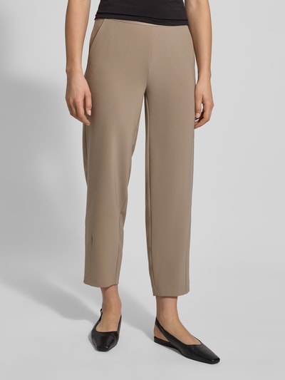 Frauenmodel trägt Stoffhose in verkürzter Passform Modell 'ELENA' von Cambio, Material-Mix, lockerer Schnitt, Elastischer-Logo-Bund, französische Eingrifftaschen, Gesäßtaschen, Farbe Beige, Ganzkörperansicht von vorne.