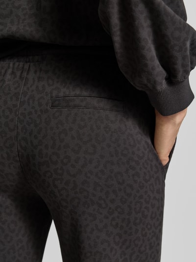 Vrouwenmodel draagt Wide Leg Sweatpants uit katoenmix van Juvia, donkergrijs met dierenprint, steekzakken, detailopname heup.