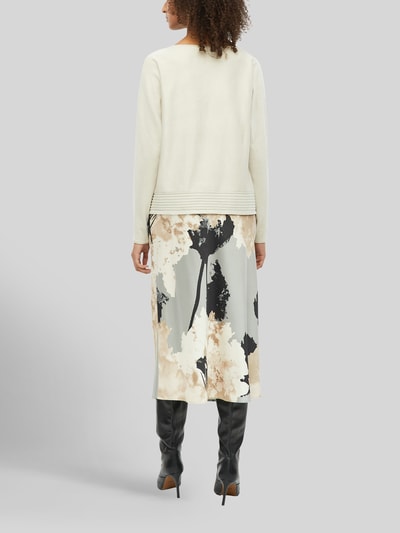 Frauenmodel trägt Relaxed Fit Pullover aus Viskose-Mix von s.Oliver BLACK LABEL in Creme, kombiniert mit gemusterter Rock, Ganzkörperansicht Rückansicht.