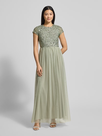 Kobiece model prezentuje Sukienka wieczorowa z cekinowym obszyciem od Lace & Beads, siateczka, taliowany krój, długość maxi, jednokolorowy, okrągły dekolt, nieprzezroczysta halka, całość w odcieniach jasnej zieleni, widok całej sylwetki z przodu.