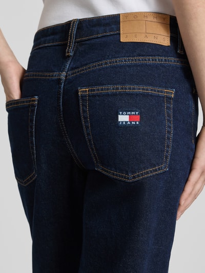Frauenmodel trägt Straight Fit Jeans aus Baumwoll-Mix Modell 'SOPHIE' von Tommy Jeans in Dark Wash Denim-Optik mit Label-Patch, Label-Prägung, 5-Pocket-Design und Twill-Materialverarbeitung, Nahaufnahme Rückansicht.