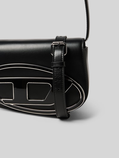 Produktfoto, schwarze Shoulder Bag mit Logo-Detail von Diesel, glatte Oberfläche, silberne Akzente, Magnetverschluss, strukturierte Formen