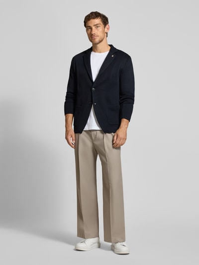 Männermodel trägt Regular Fit cardigan met wol van Manuel Ritz, Materiaalmix, Reverskraag, Tricotlook, opgestikte zakken, Ruglengte maat M 74 cm, Mouwlengte maat M 61 cm, Ganzkörperansicht van voren