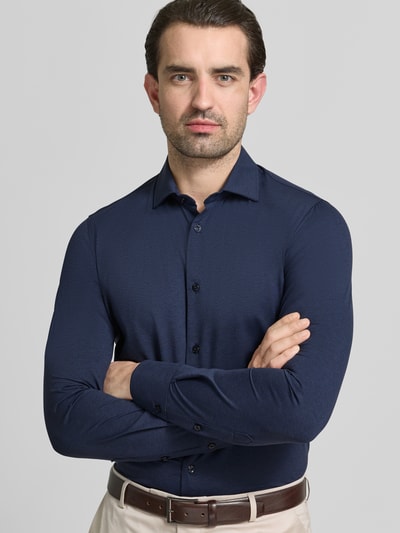 Męski model nosi Slim Fit Business-Hemd mit Knopfleiste von CRUNA, materiał z domieszką stretchu, krój slim fit, kent, widok na górną część ciała z przodu.