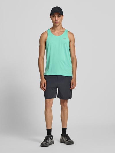 Männermodel trägt Tanktop mit Logo und Rundhalsausschnitt von New Balance in Regular-Fit, Rückansicht, Rückenlänge 66 cm bei Größe M, Ganzkörperansicht von vorne.