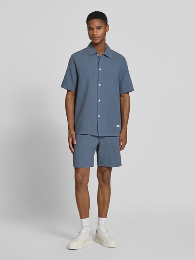 Męski model nosi Regular Fit Freizeithemd aus reiner Baumwolle von Marc O'Polo Denim, jednokolorowy, faktura wafla, kołnierzyk typu kent, listwa guzikowa jednorzędowa, naszywka z logo, krótki rękaw, bawełna, koszula casualowa, Ganzkörperansicht von vorne