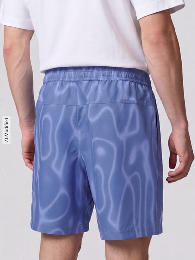 Männermodel trägt Regular Fit Sportshorts mit Dri-FIT-Technologie von Nike in Hellblau mit welligen Mustern, Herren Sportshorts von Nike Training, Ganzkörperansicht Rückansicht, KI-modifiziertes Bild.